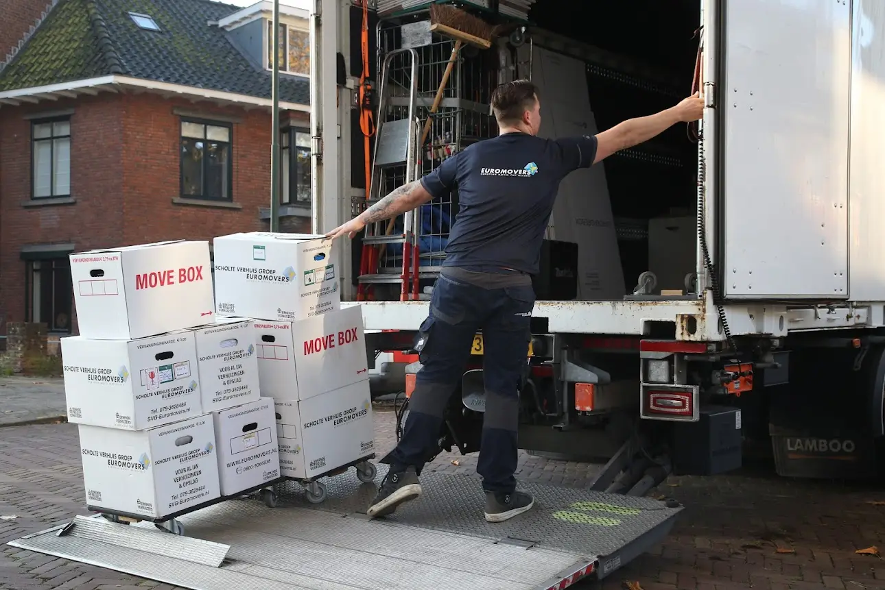 SVG-verhuizer laadt verhuisdozen via de laadklep van de verhuiswagen