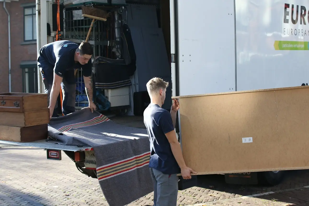 Twee SVG-verhuizers laden meubels in de verhuiswagen